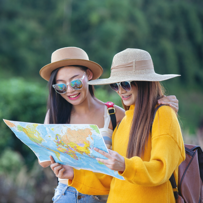 two female tourists hold a map to find places